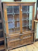 Old Charm display cabinet having two leaded glazed doors above two carved panel doors, 161cm by 107.