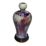 Chinese Sang de Boeuf porcelain vase with flambé and blue glaze and garlic bulb neck on wooden