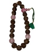 Chinese aloeswood rosary consisting of beads and a jade pendant.