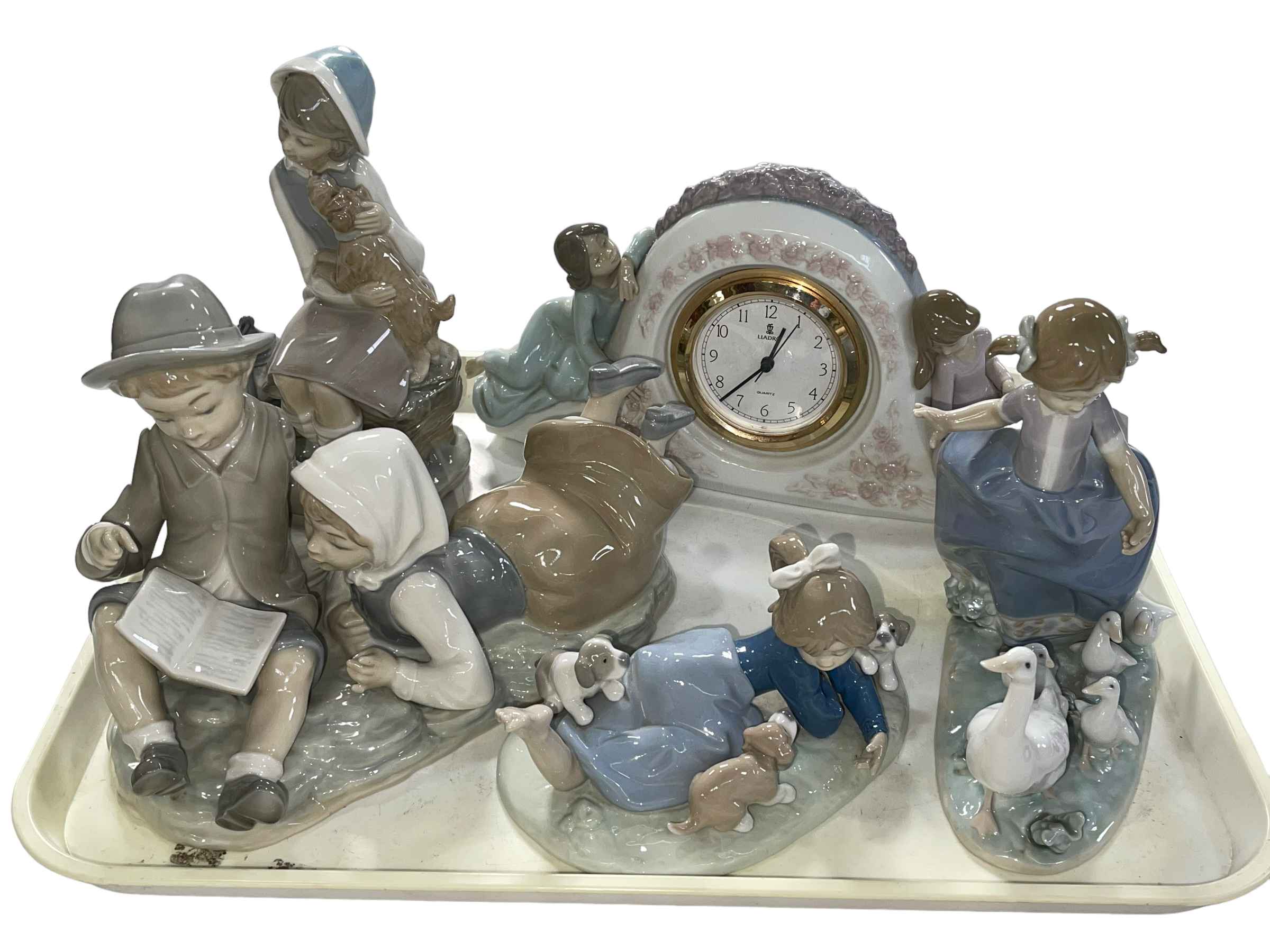 Four pieces of Lladro including Two Sisters Clock and Hurry Now, and Nao boy and girl group (3).