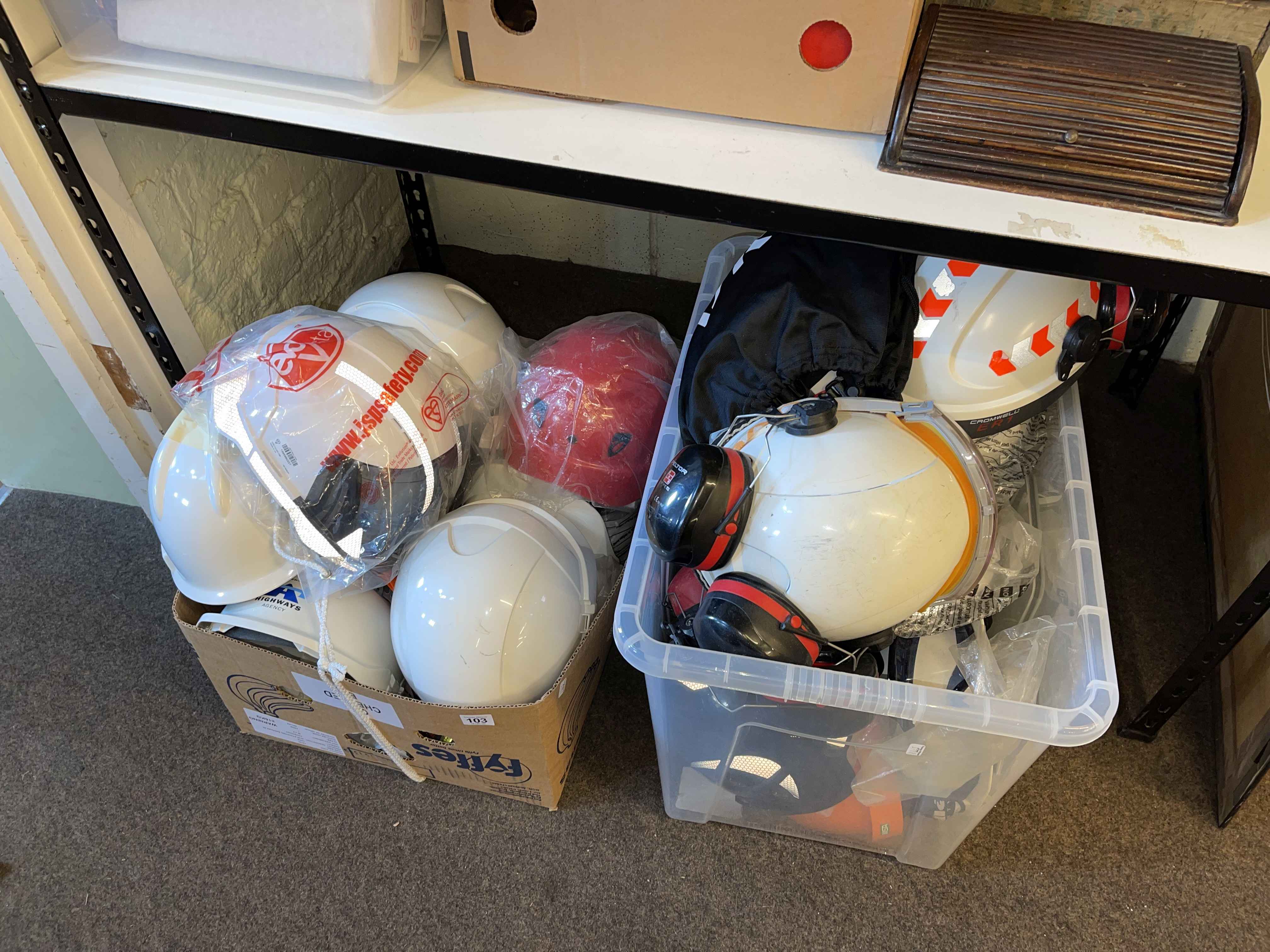 Two boxes of hard hats, goggles, ear defenders, etc.