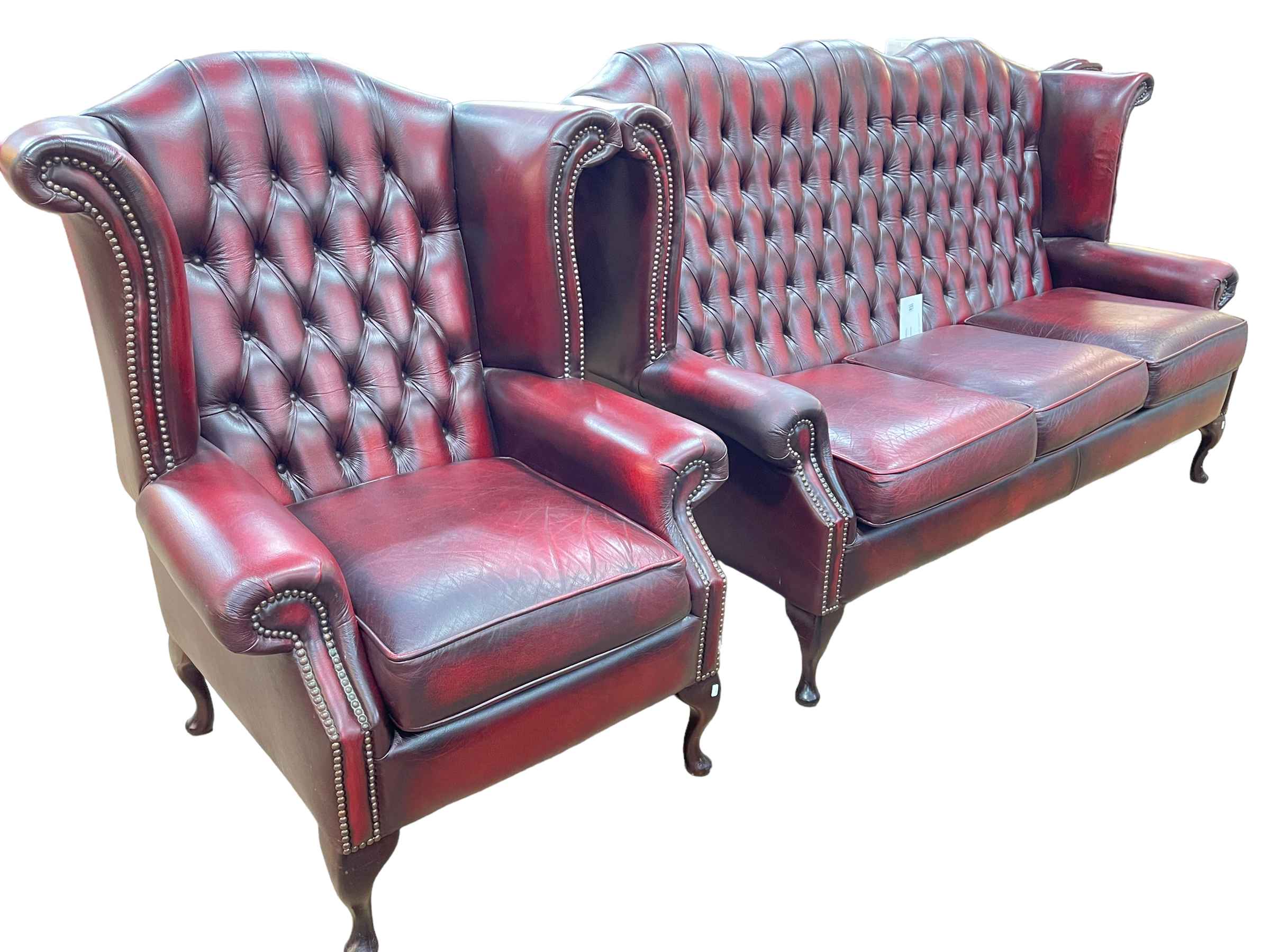 Ox blood leather button backed and studded three seater wing settee and armchair.