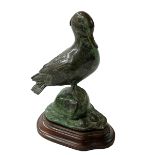 Green patinated bronze model of a duck on wooden stand, 13cm high.