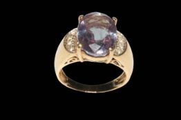 Large oval Alexandrite ring set with four small diamonds to each shoulder in 9 carat yellow gold,