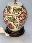 Moorcroft table lamp with floral design on ivory ground.