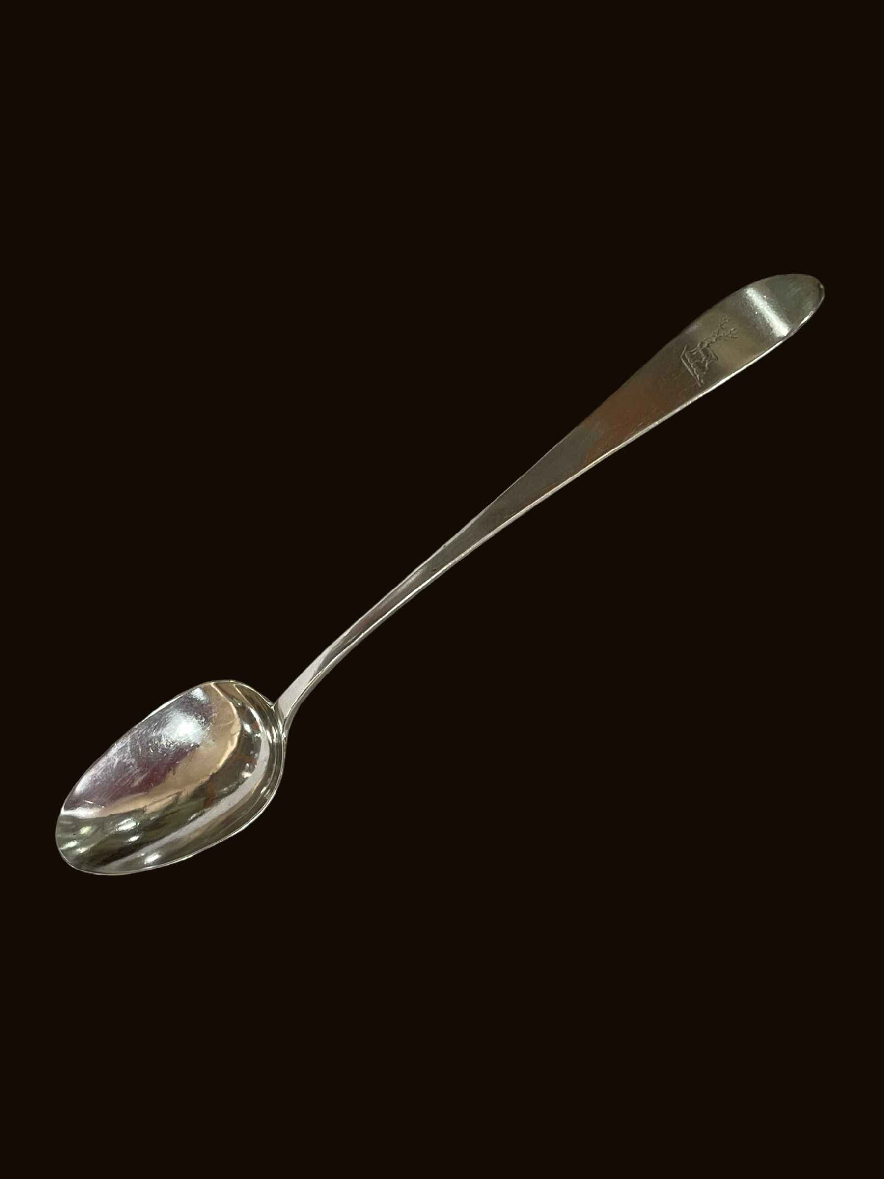 Irish silver basting spoon by Christopher Eades, Dublin 1821, bearing crest, 31cm length.