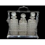 Silver plated three bottled tantalus, 34cm.