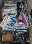 Box of single records including The Beatles.