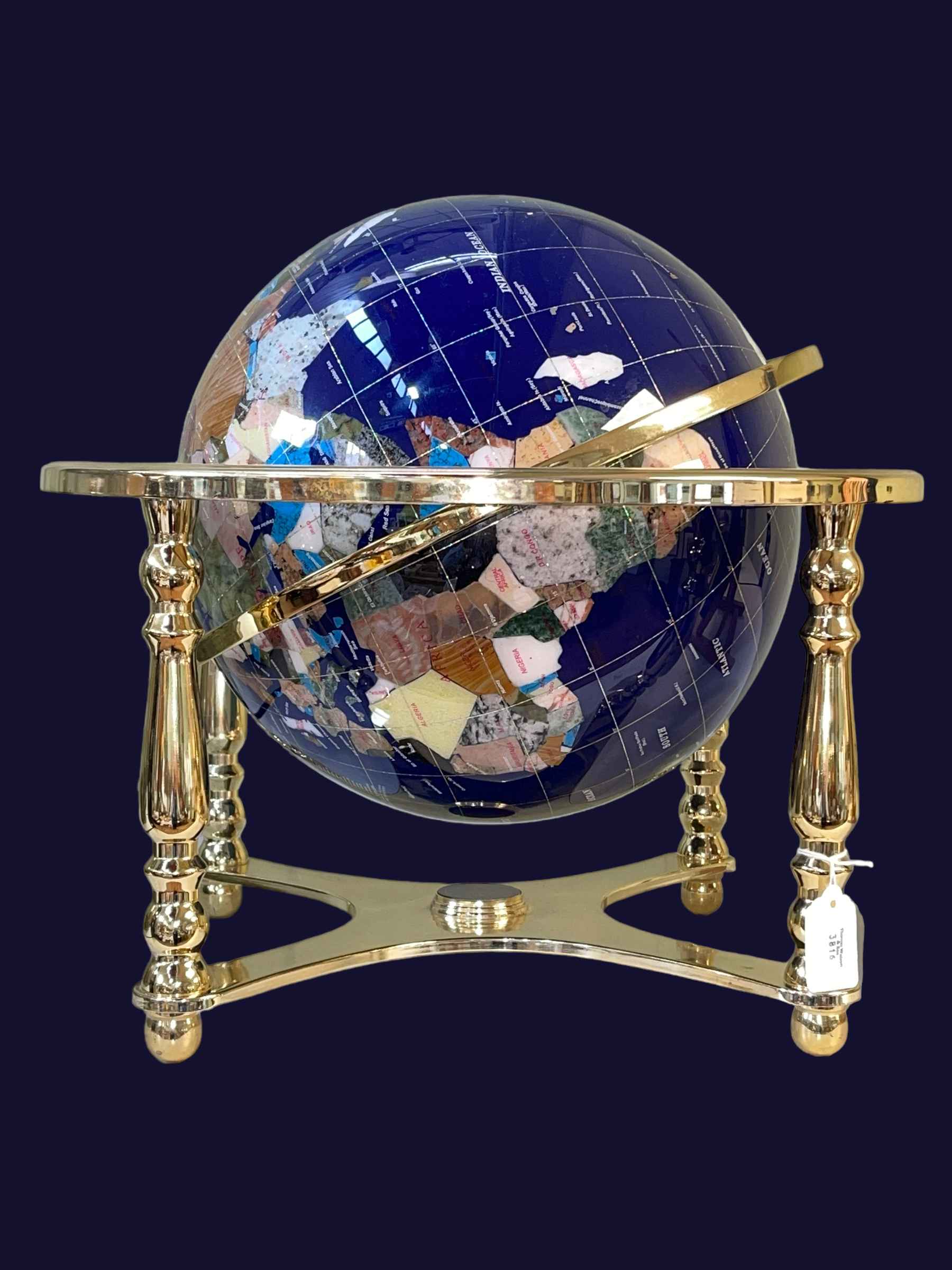 Brass mounted terrestrial globe inlaid with semi-precious gemstones, approximately 40cm high.