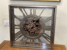 Wall mounted clock with moving cogs, 61cm by 61cm.