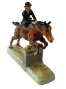 Beswick model of Huntswoman riding side saddle on jumping horse.