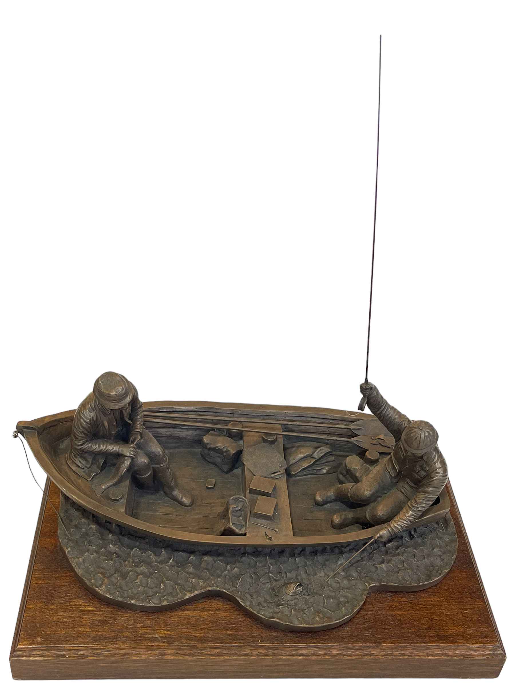 Composite fishermen sculpture on wooden plinth, 45cm long.