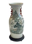 Chinese famille verté vase, with trees below mountains and having iron red fo dog handles,