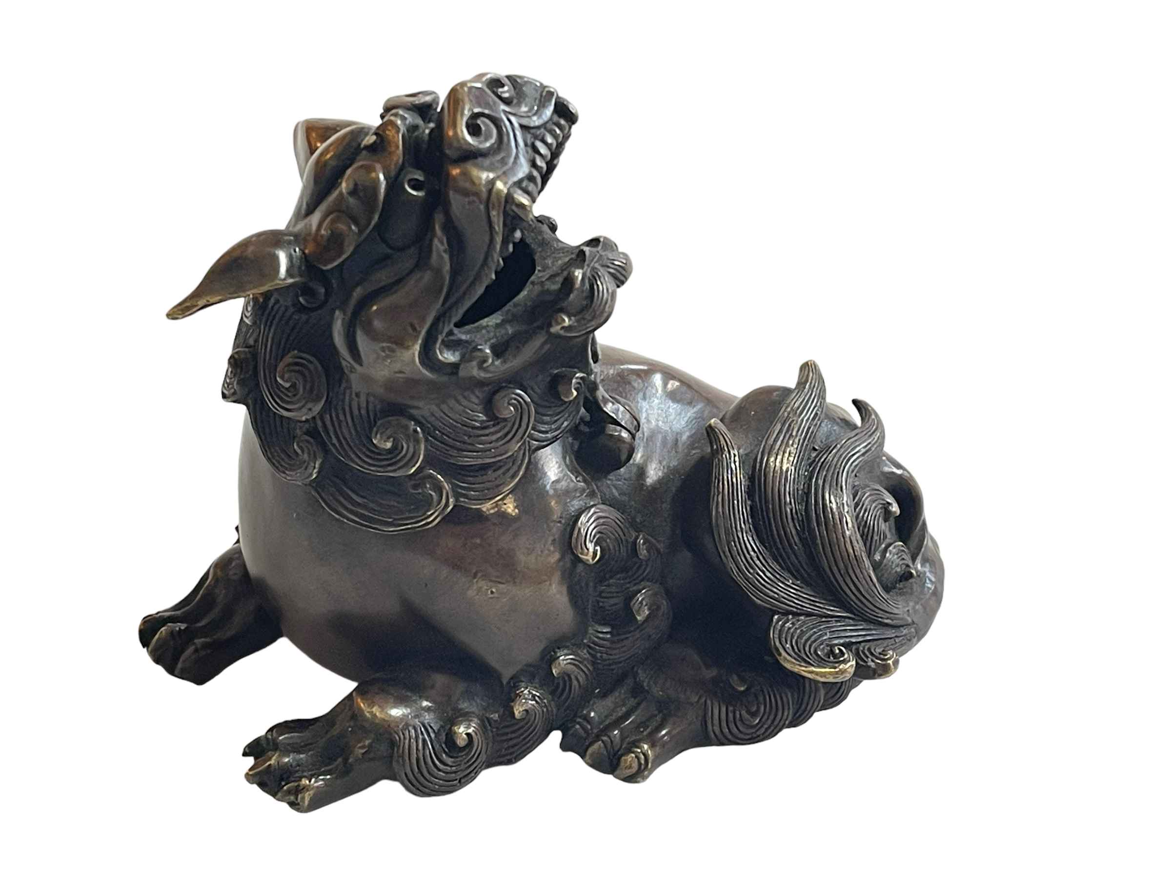 Bronze foo dog with hinged head, 13cm length.