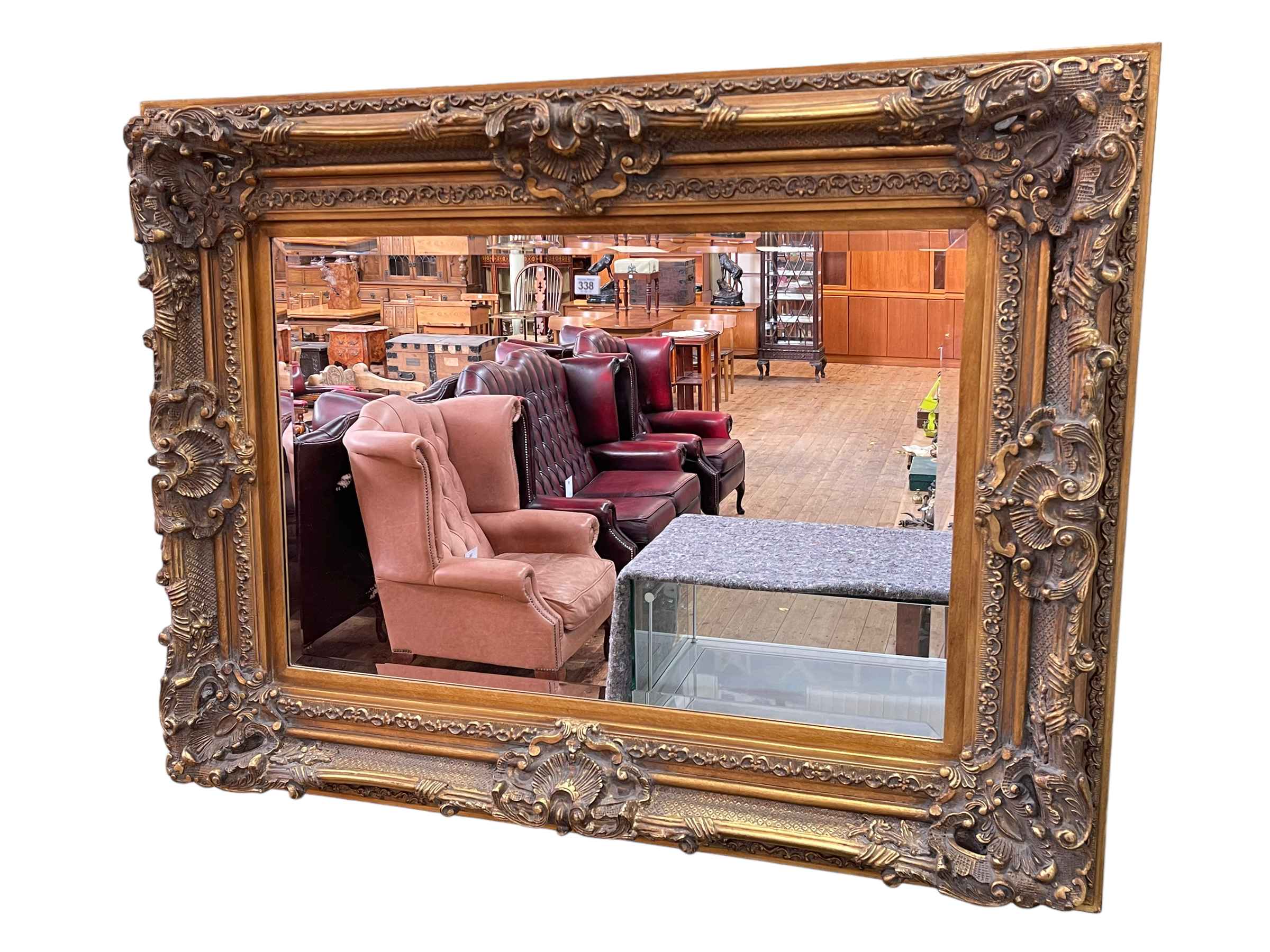 Heavily carved gilt framed rectangular bevelled wall mirror, 95cm by 126.5cm.