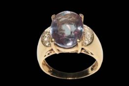 Large oval Alexandrite ring set with four small diamonds to each shoulder in 9 carat yellow gold,