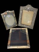 Three silver photograph frames, largest 30cm by 25cm.