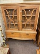 Pine cabinet bookcase having two glazed doors above two drawers on short cabriole legs,