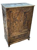 Oriental carved camphorwood cabinet having two figural carved panel doors above a long drawer,