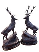 Pair of impressive bronze models of stags on rocky outcrops on marble bases, 74cm high.