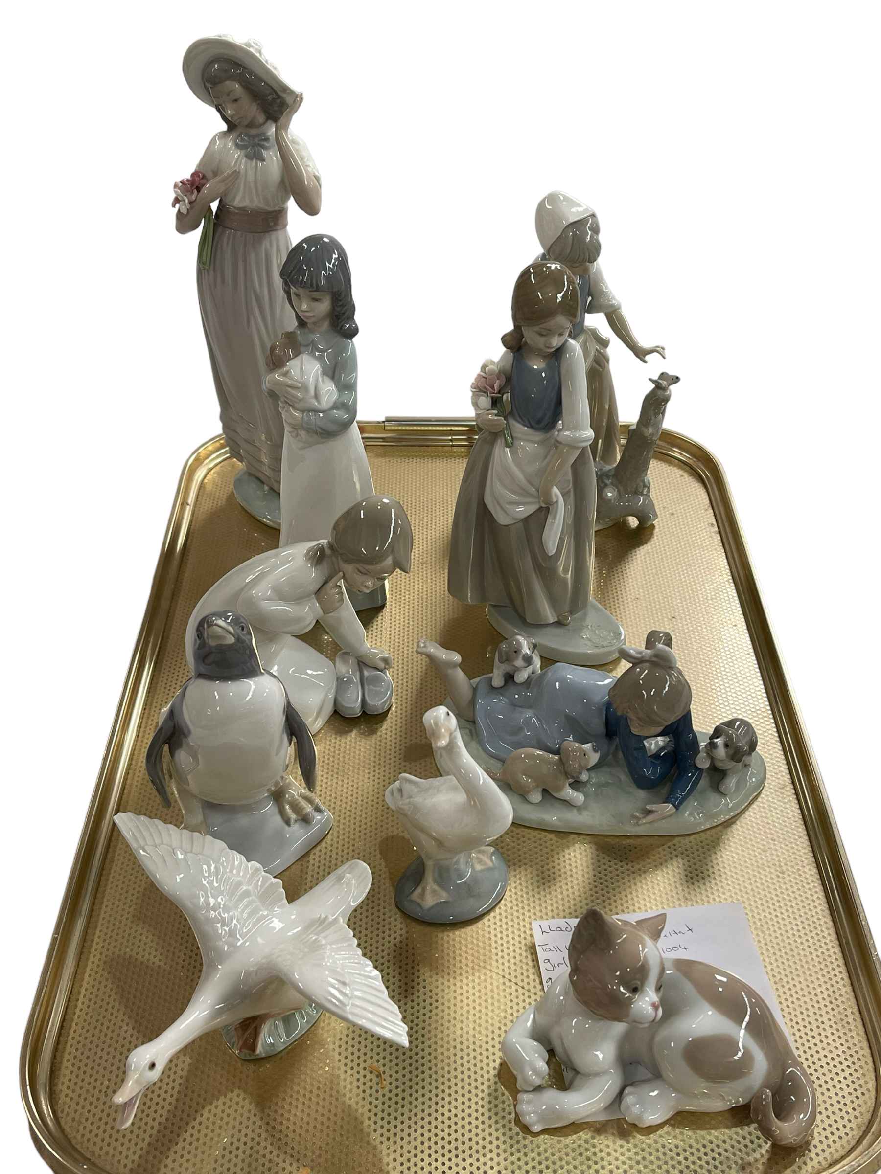 Six Lladro and four Nao ornaments including Girl with Puppies, Penguin, Cat, etc.