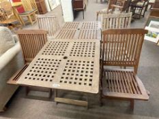 Two teak lattice topped folding patio tables and four folding chairs.