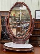 Victorian oval mahogany toilet mirror on marble topped base with bun feet, 92cm by 63.5cm.