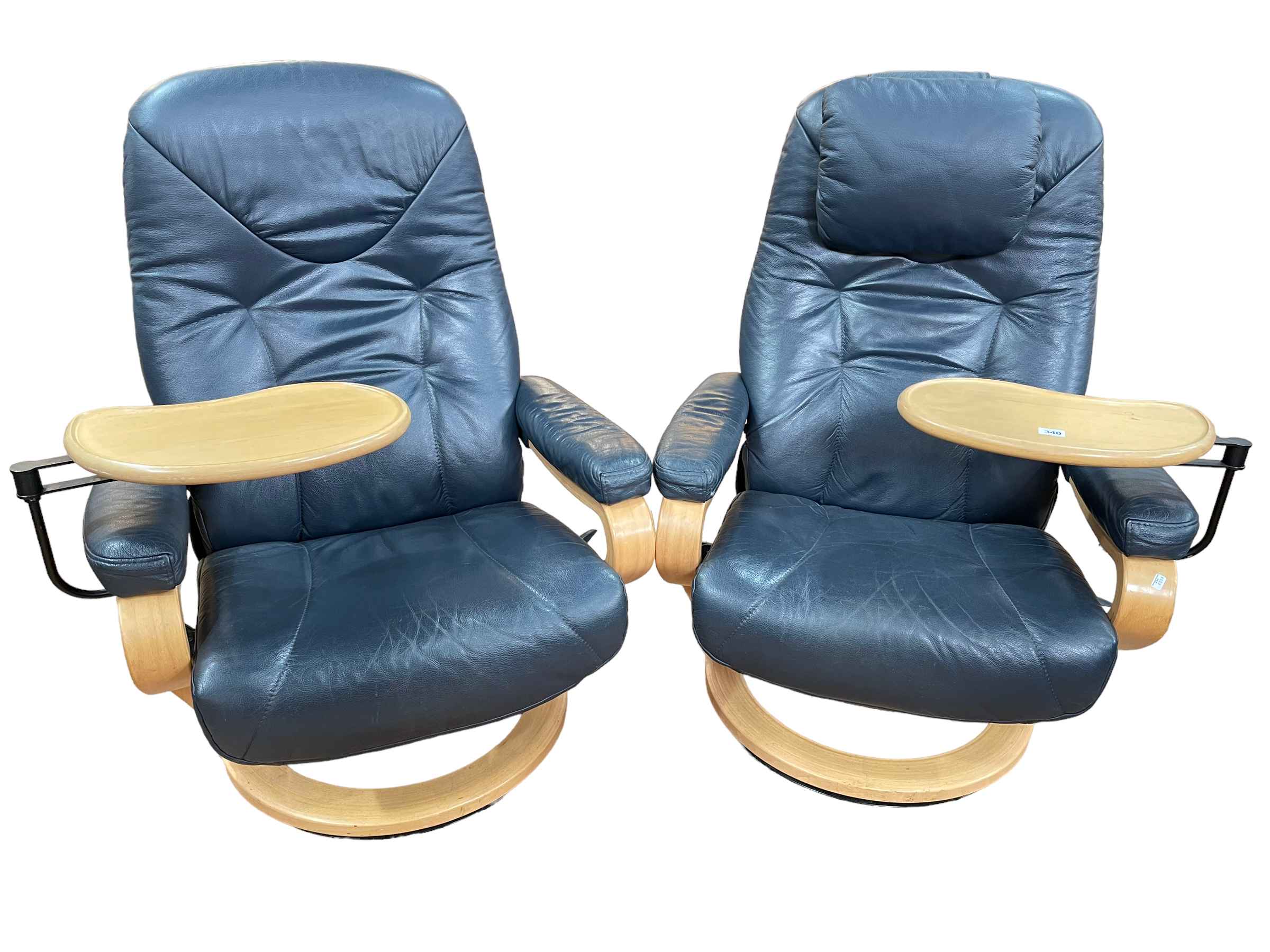 Pair blue leather reclining swivel armchairs with adjustable trays.