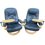 Pair blue leather reclining swivel armchairs with adjustable trays.