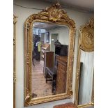 Gilt framed rectangular bevelled wall mirror with foliate crest, 157cm by 85cm.