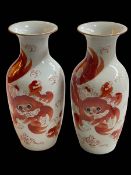 Pair of Chinese Alum Red Fu dog decorated vases, 27.5cm.