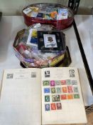 Two tins of pin badges and stamp album.