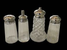 Four silver topped sugar shakers.