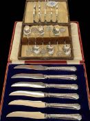 Silver five bar toast rack, silver souvenir coffee spoons, and silver handled tea knives.
