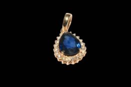 Pear shaped sapphire and diamond cluster pendant set in 18 carat yellow gold,