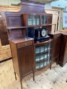 A late Victorian inlaid mahogany cabinet having a pair of upper bowfront astragal glazed doors,