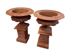 Pair cast rusted garden urns on stands, 63cm by 42cm diameter.