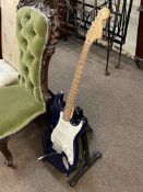 Electric guitar marked Squier Strat by Fender.