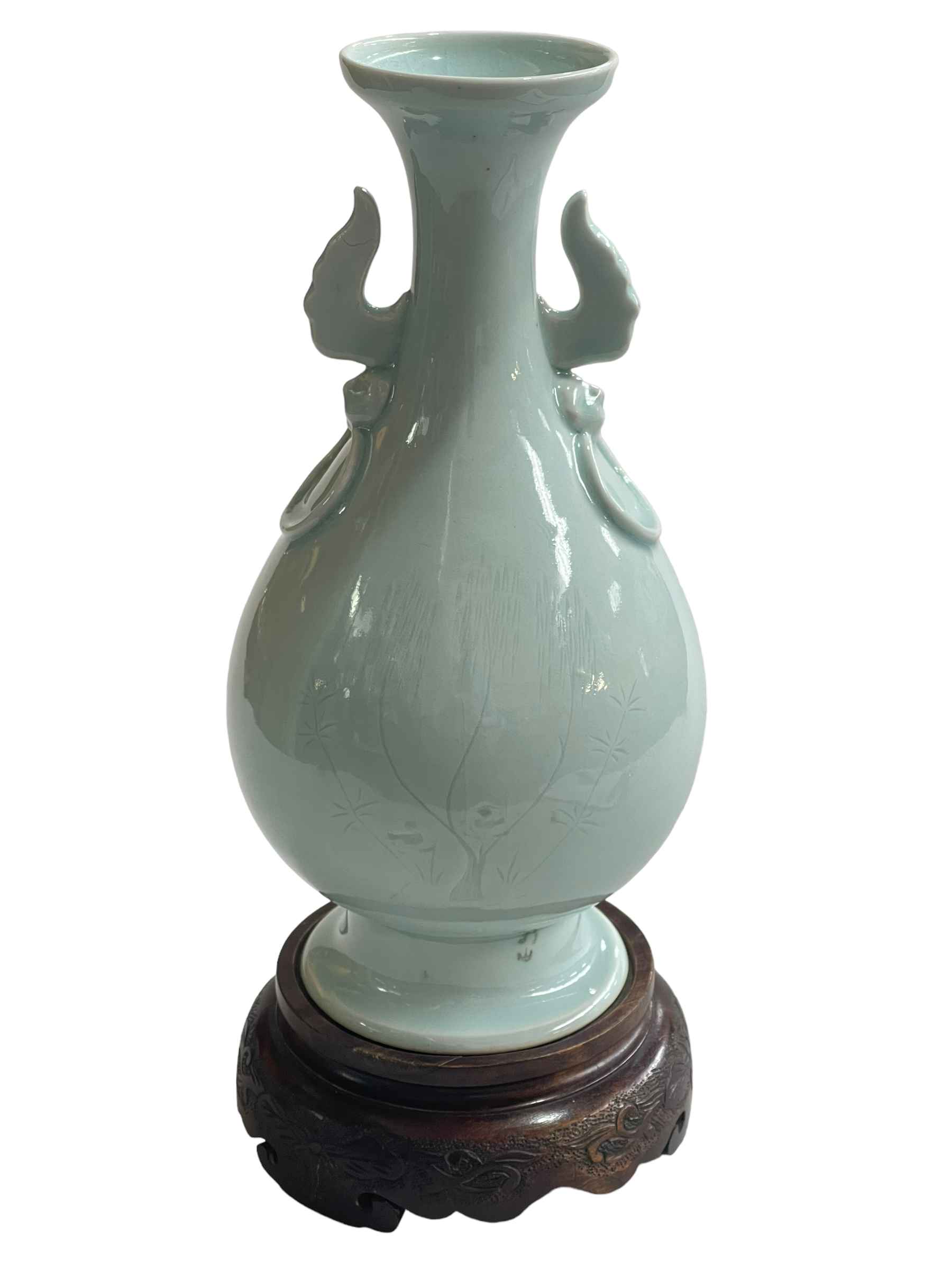 Chinese pale blue porcelain vase with twin handles of bulbous form with flared rim on wood stand,