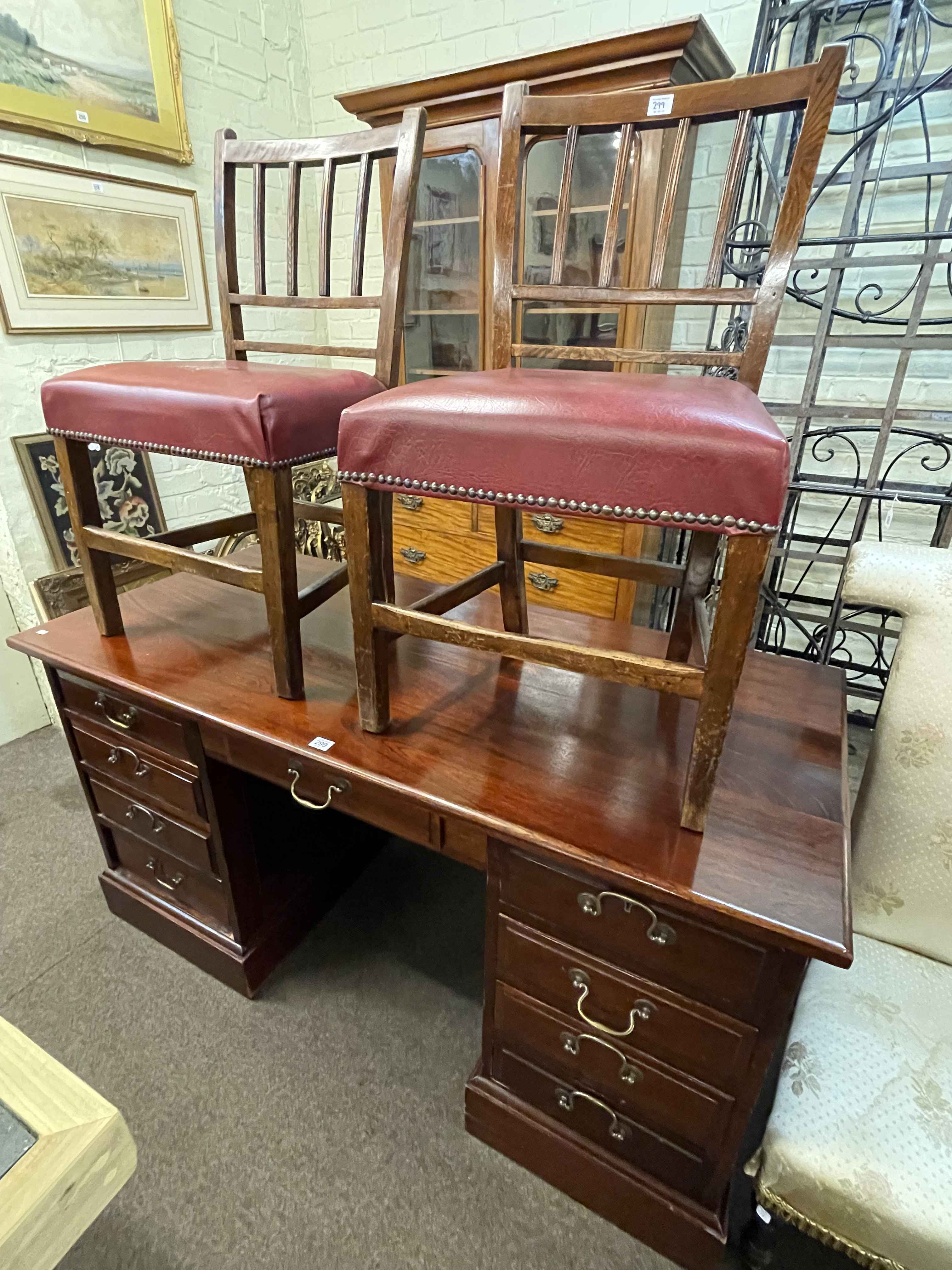 Mahogany nine drawer pedestal desk and pair antique oak side chairs, desk 77cm by 145cm by 66cm.