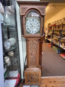 Antique carved oak eight day longcase clock having painted arched dial, 209cm.