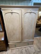 Pine wardrobe having two panelled doors above a long drawer, 194cm by 141cm by 62cm.