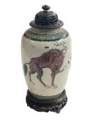 Chinese Famille Verte vase decorated with mythical beast with carved wood stand and lid, 27cm high.