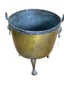 19th Century brass log bin raised on three claw feet with lion mask ring handles, 65cm.