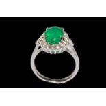 Emerald and diamond cluster ring set in 18 carat white gold, the oval emerald 2.