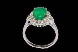 Emerald and diamond cluster ring set in 18 carat white gold, the oval emerald 2.