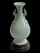 Chinese pale blue porcelain vase with twin handles of bulbous form with flared rim on wood stand,