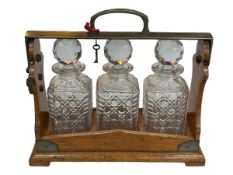 Vintage oak and brass mounted three bottle tantalus marked Betjemanns, with key, 30cm.