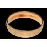 9 carat gold bangle, half engraved with scrolling foliage, 6.5cm across.