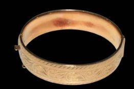 9 carat gold bangle, half engraved with scrolling foliage, 6.5cm across.